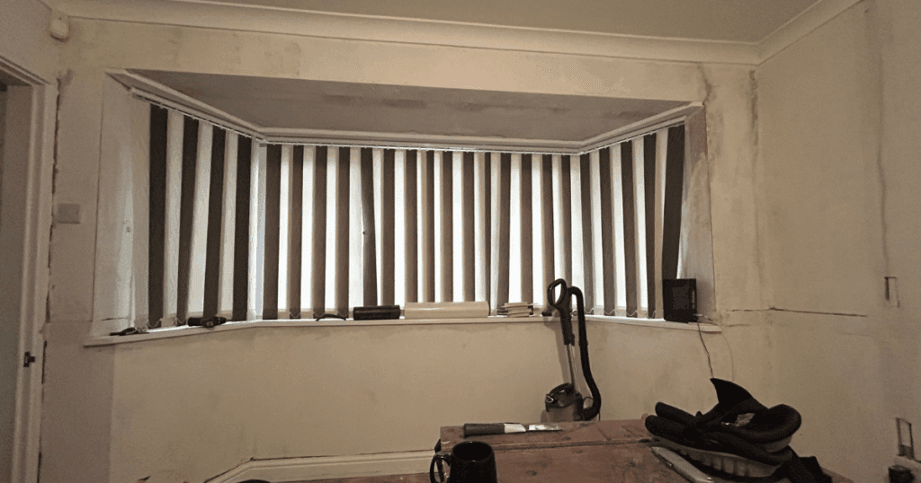 A bay window with old fashioned vertical blinds